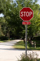 STOP sign in full sun with path and fence behind, empty left side for copy space