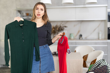 Upset woman not happy with her old dresses in wardrobe for Christmas celebration