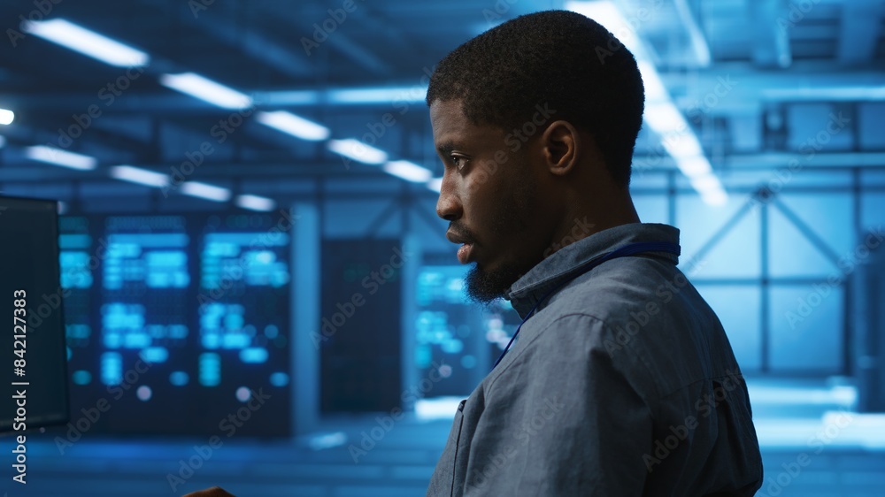 Poster african american man working in server hub capable of processing vast amounts of data. it programmer
