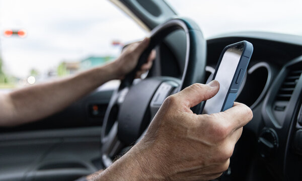 Man texting while driving horizontal shot