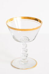 empty vintage champagne glass with gold rim isolated