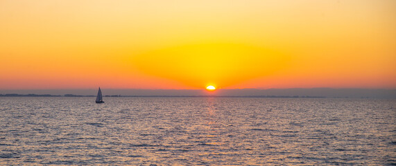 sea sunset with a sailboat, background of vacation, orange