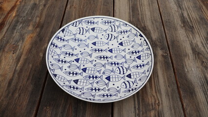 Empty plate with images on a wooden table close-up, outdoors