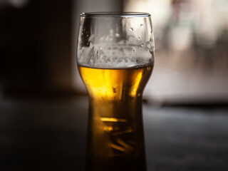 Selective blur on a Closeup on a beer mug containing a light beer, pilsner / lager style, served in a standard pint size glass.