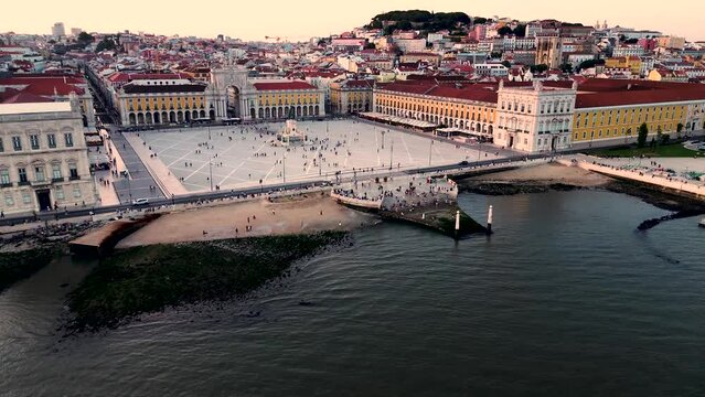 A magnificent aerial view of Tourist center of the old European city, the capital of Portugal - Lisbon and river - Teju, Tagus. Warm sunset light. 4k stock drone video.