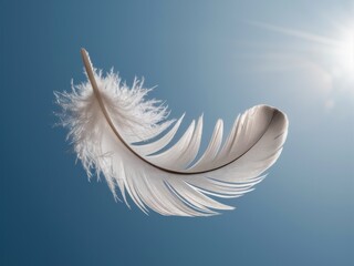 Obraz premium White Feather Floating Against Clear Blue Sky with Bright Sunlight
