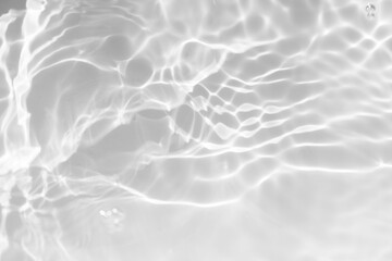 White water with ripples on the surface. Defocus blurred transparent white colored clear calm water surface texture with splashes and bubbles. Water waves with shining pattern texture background.