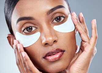 Skincare, portrait and Indian woman with eye mask in studio for beauty, dermatology and hydration cosmetics on grey background. Wellness, face or model with collagen patch for anti aging treatment