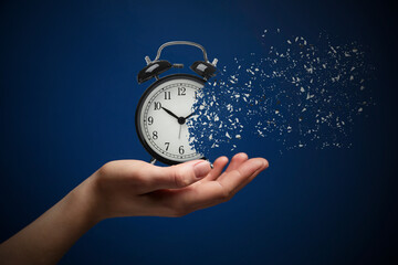 Time running out. Woman with dissolving alarm clock on blue background, closeup