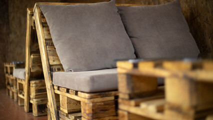 Upholstered armchairs in restaurant. Craft furniture. Pillows for relaxation.