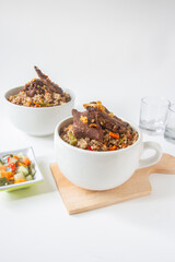 kebuli traditional brown rice with meat on wood plate, isolated background