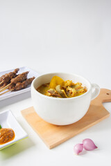 Gulai curry, indonesian traditional food on wood plate with onion, isolated background