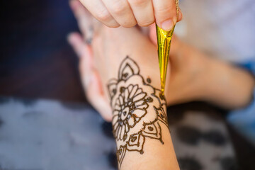 Applying Intricate Henna Tattoo on a Womans Wrist