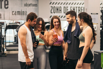 Naklejka premium friends talking and using mobiles in a gym