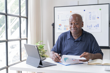 Creative african businessman senior american worker using computer device in office,chat online, thinking business solution planning difficult decision pondering strategy come up with idea.