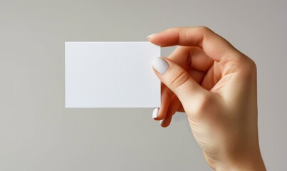 Fototapeta premium A female hand is holding a white business card