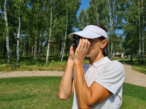 Woman Using Golf Rangefinder on Course During Summer Day