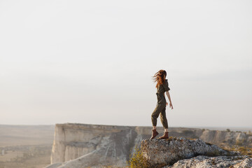 Desert adventure woman standing on top of rock gazing at horizon in remote travel destination