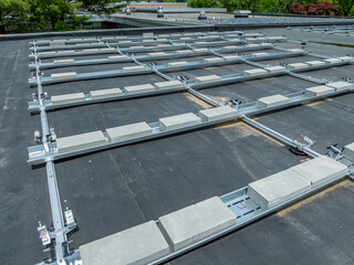 Photo of framing and concrete block ballast blocks for new solar panels being installed on a flat...