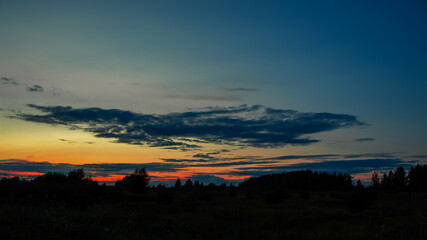 Obraz premium Summer sunrise or sunset on the field or forest. Summer landscape. Beautiful sky and color.