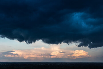 Storm clouds cover the landscape. Tragic gloomy sky. Panorama. approach of a storm, thunderclouds and clear skies at sunset.