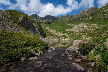 View of the Dukka lake "Rybka" and the Malaya Dukka River on the slopes of the Arkasar ridge in the North Caucasus on a sunny summer day, Arkhyz, Karachay-Cherkessia, Russia © Ula Ulachka