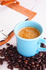 エスプレッソに牛乳をたっぷり入れたコーヒーのカフェ・ラッテと、深煎りしたコーヒー豆
