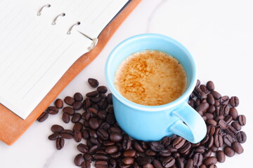 エスプレッソに牛乳をたっぷり入れたコーヒーのカフェ・ラッテと、深煎りしたコーヒー豆
