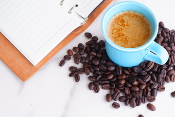 エスプレッソに牛乳をたっぷり入れたコーヒーのカフェ・ラッテと、深煎りしたコーヒー豆
