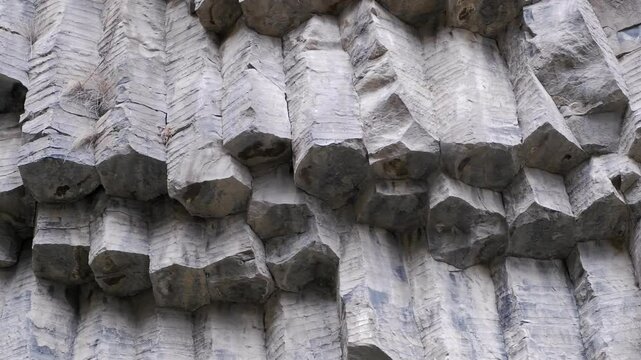 Pan across broken bases of clean ancient basalt rock columns, Armenia