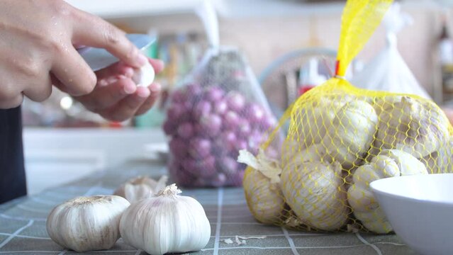 Woman peeling the garlics prepare for cook