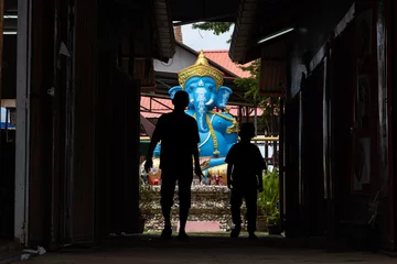 Fotobehang Gang People walk through a narrow lane to the colorful elephant – Lord Ganesha  © milkovasa