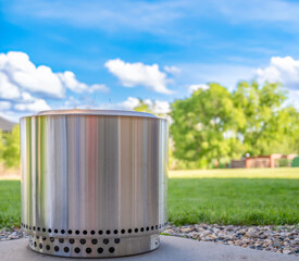 Smokeless stainless steel fire pit in a residential backyard in the spring