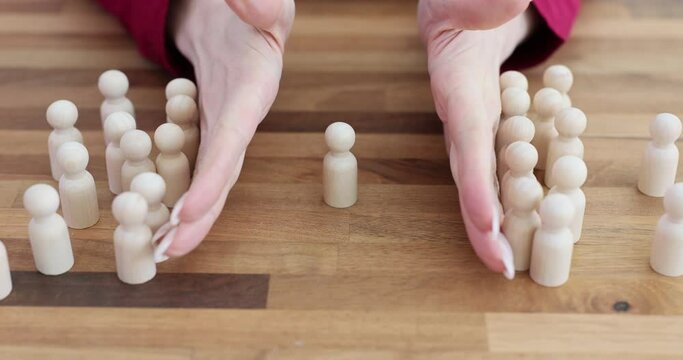 Wooden figures of people gathered together and formed a crowd and one outcast