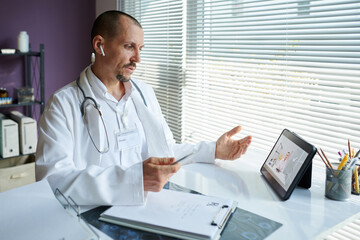 Physician calling colleague from another clinic to discuss prescription for patient