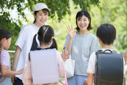 小学生と保護者、朝の通学の登校班の送迎の様子　今日も元気に いってらっしゃい！子供たちの顔無し