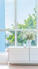 Fototapeta premium Elegant modern sideboard next to a window in a room bathed with natural lighting. Home interior composition.