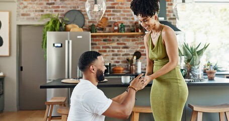 Couple, proposal and happy with engagement in home for commitment, marriage promise and ring box on...