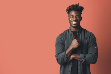 Stylish university student smiling confidently with pen against a coral background