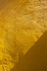 Yellow cement wall with morning day light background, blank yellow concrete wall texture background, vertical style