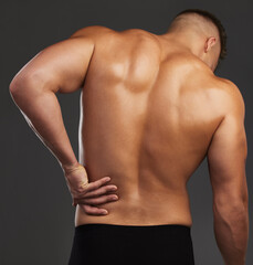 Fototapeta premium Back pain, fitness and hands of man in studio with workout mistake, fail or muscle inflammation on black background. Sports, injury and bodybuilder with backache, wound or anatomy risk and emergency