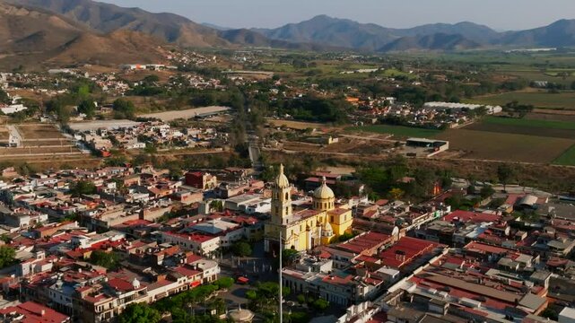 Scenic aerial orbit view of Santuario Diosesano Church and the rural background in Tamazula de Gordiano