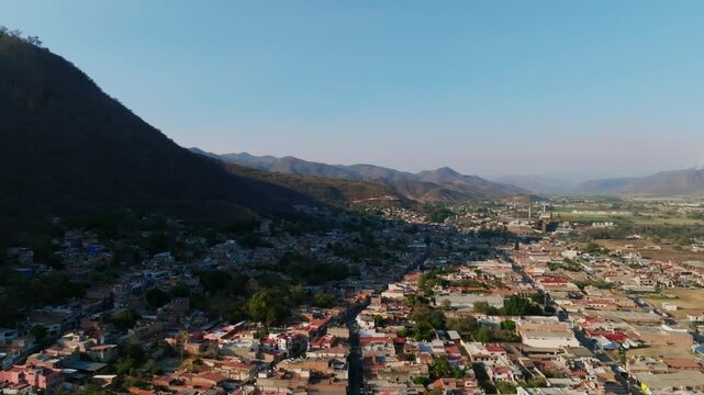 Mexican town Tamazula de Gordiano's residential area. Dolly in aerial overlooking the city and mountains