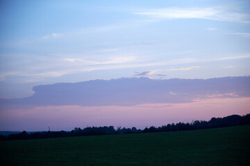Fototapeta premium sunset view of the pink grey sky and trees before a thunderstorm