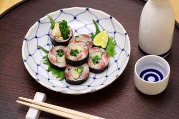 A Japanese sushi restaurant roll dish of pickled sardines and ginger wrapped in nori seaweed.