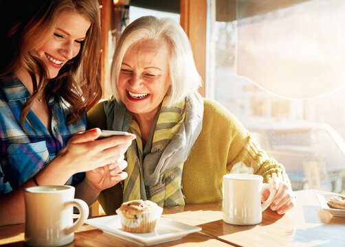 Family, mother and daughter in cafe, cellphone and conversation with social media, coffee and digital app. People, mama and girl with smartphone, texting in restaurant and happiness with cappuccino