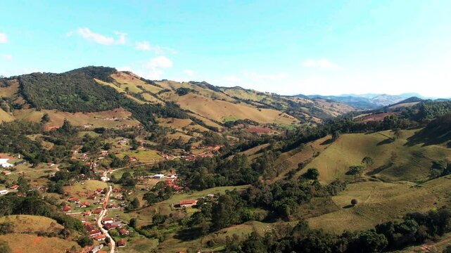 Landscape pan over mountainous range and valley of Delfim Moreira Minas Gerais Brazil rural suburbs town community farming countryside travel tourism