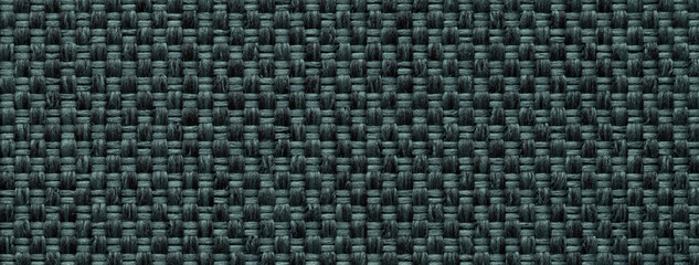 Texture of dark green color background from woven textile material with wicker pattern, macro.