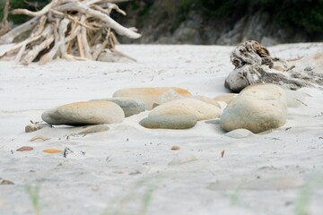 Tranquil Beach Scene: Stones on Shoreline, Coastal Serenity, Pebbles by Ocean, Natural Beauty