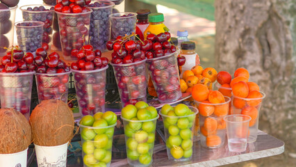 Juicy fruits and berries in plastic cups, perfect for a hot day refreshment
